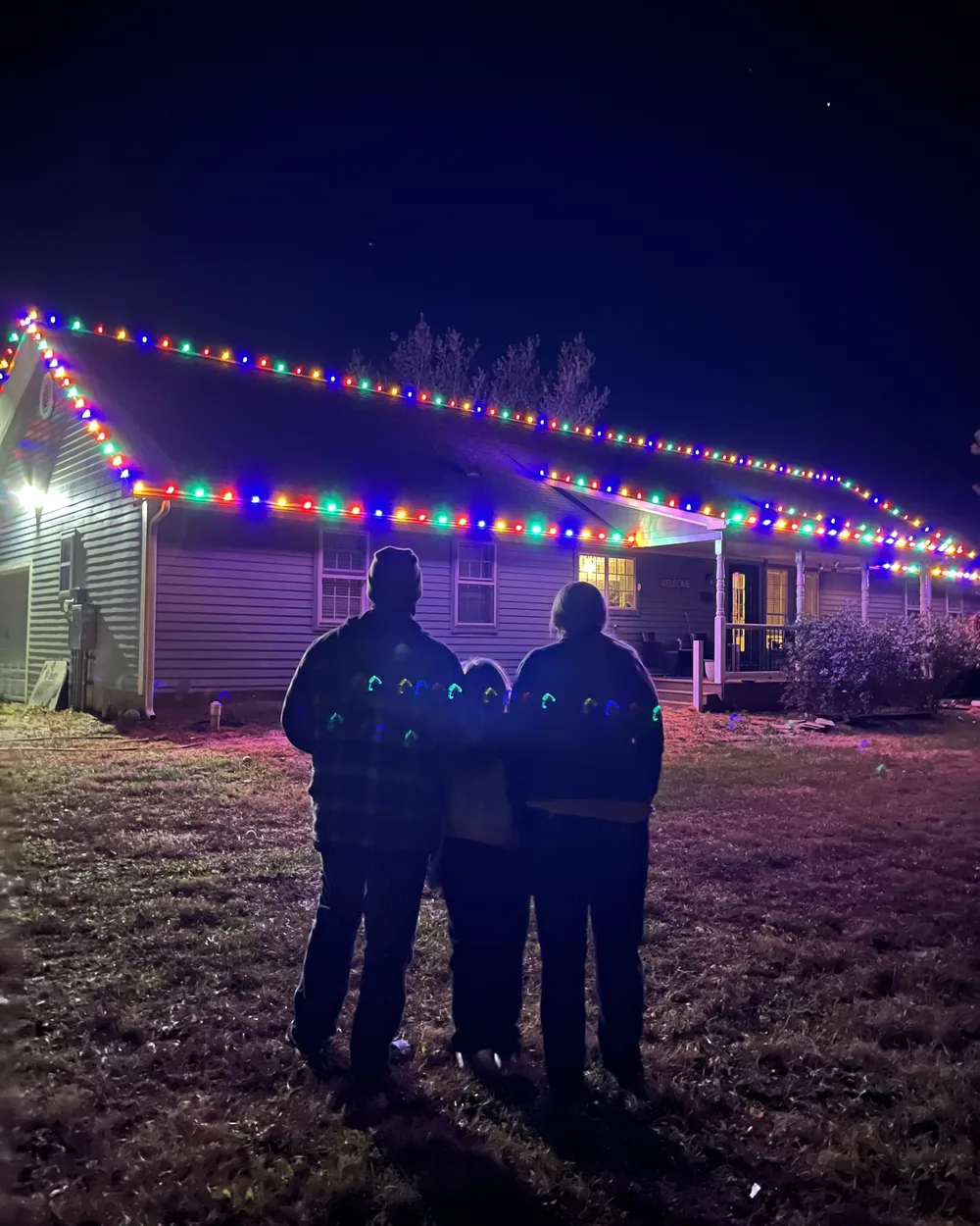 Homeowners looking at their newly lit house