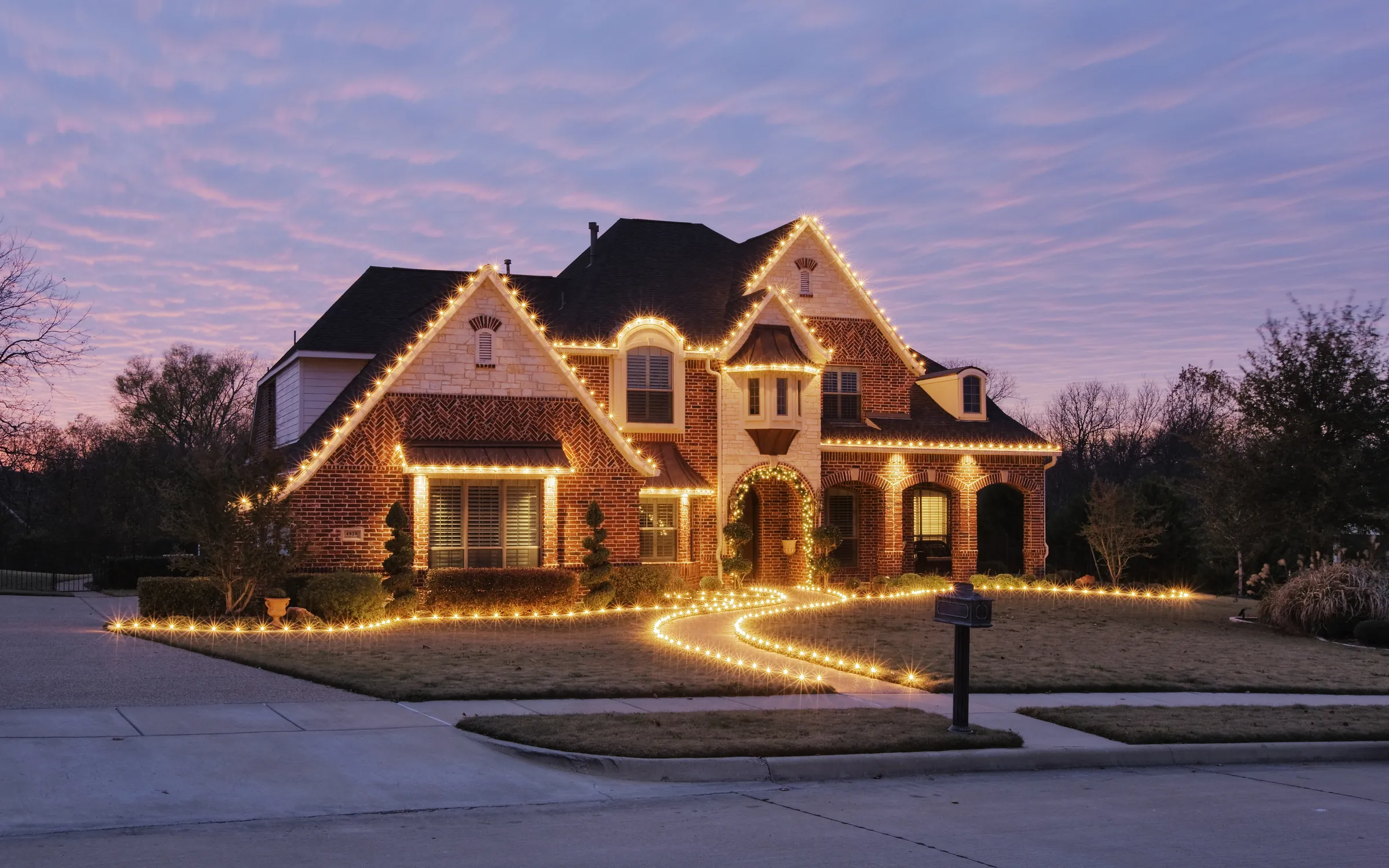 Home in southeast Missouri with warm holiday roofline lighting at dusk